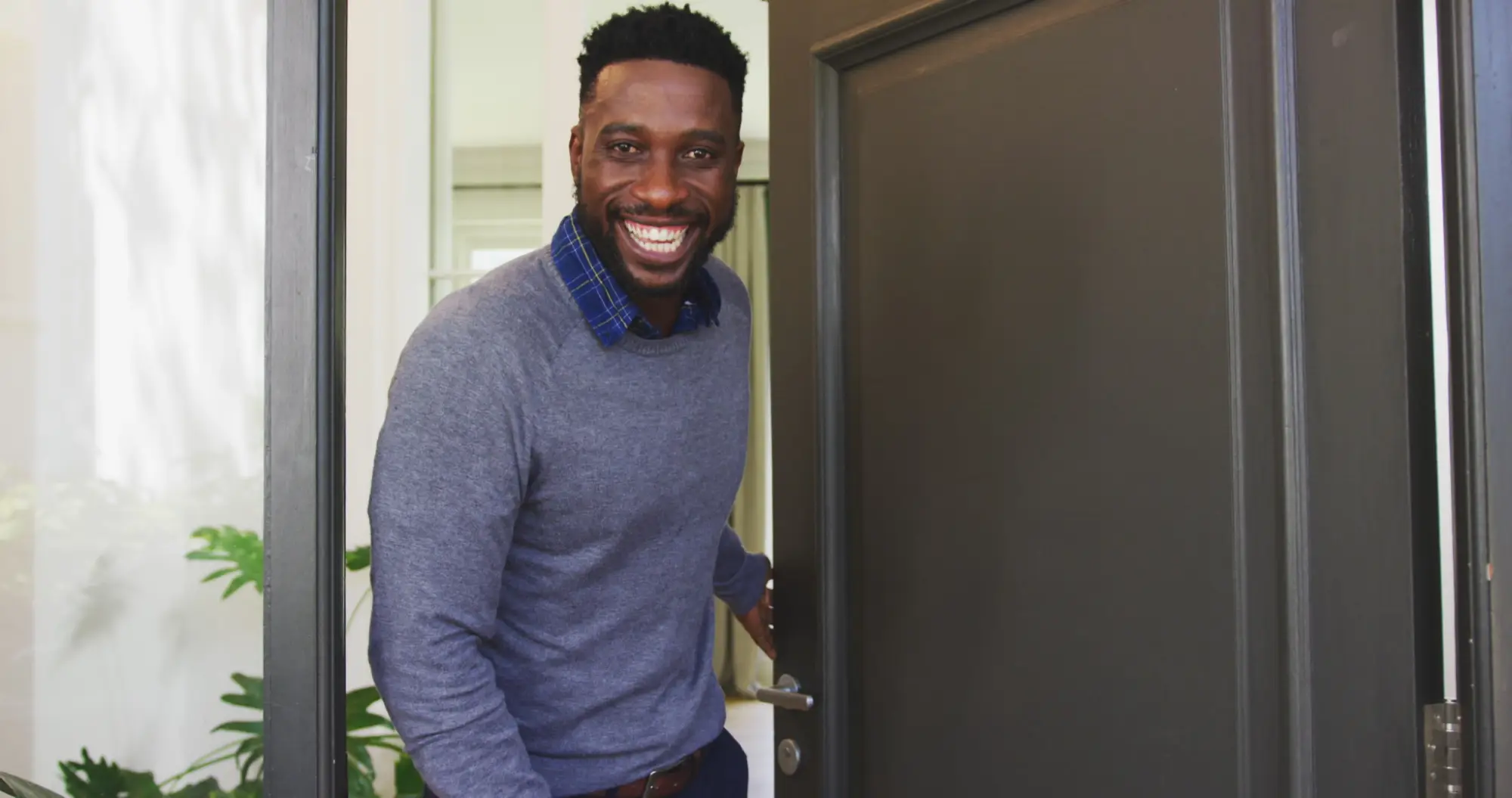 Homeowner smiling as he opens his front door